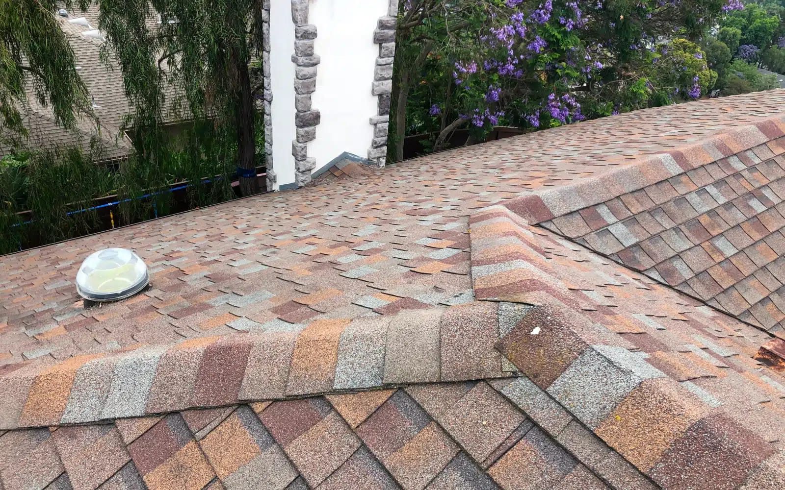 Aging asphalt shingle roof showing worn shingles and ridge detail before roof replacement in Encinitas, CA.