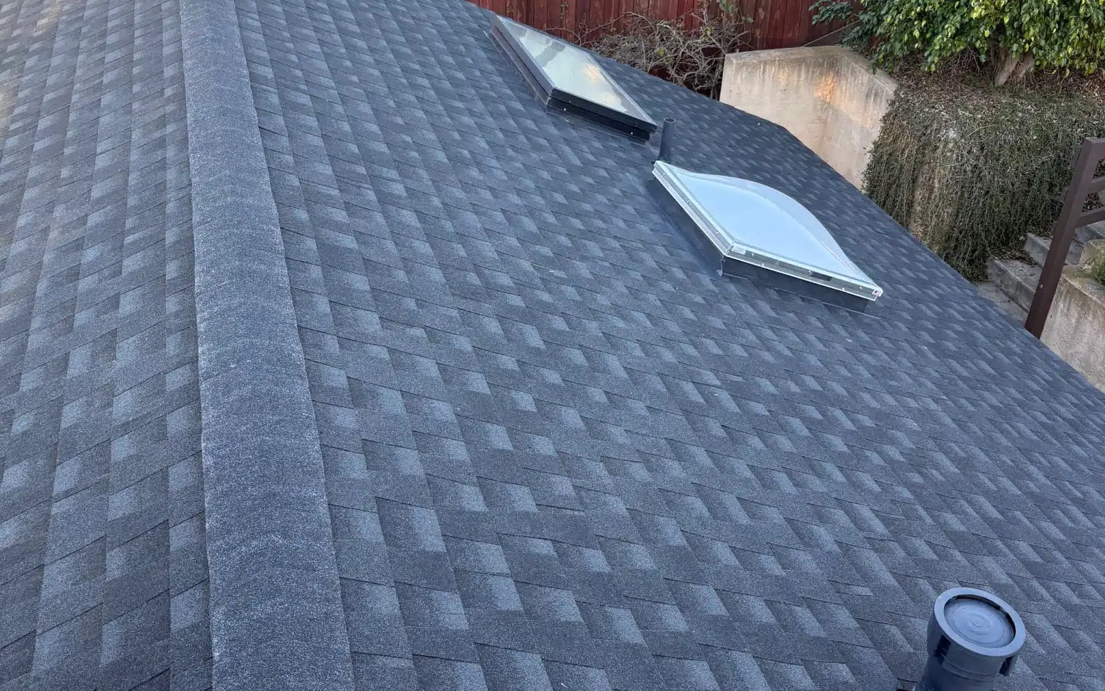 Asphalt shingle roof replacement with properly installed ridge vent and skylights following full replacement in Del Mar, California.