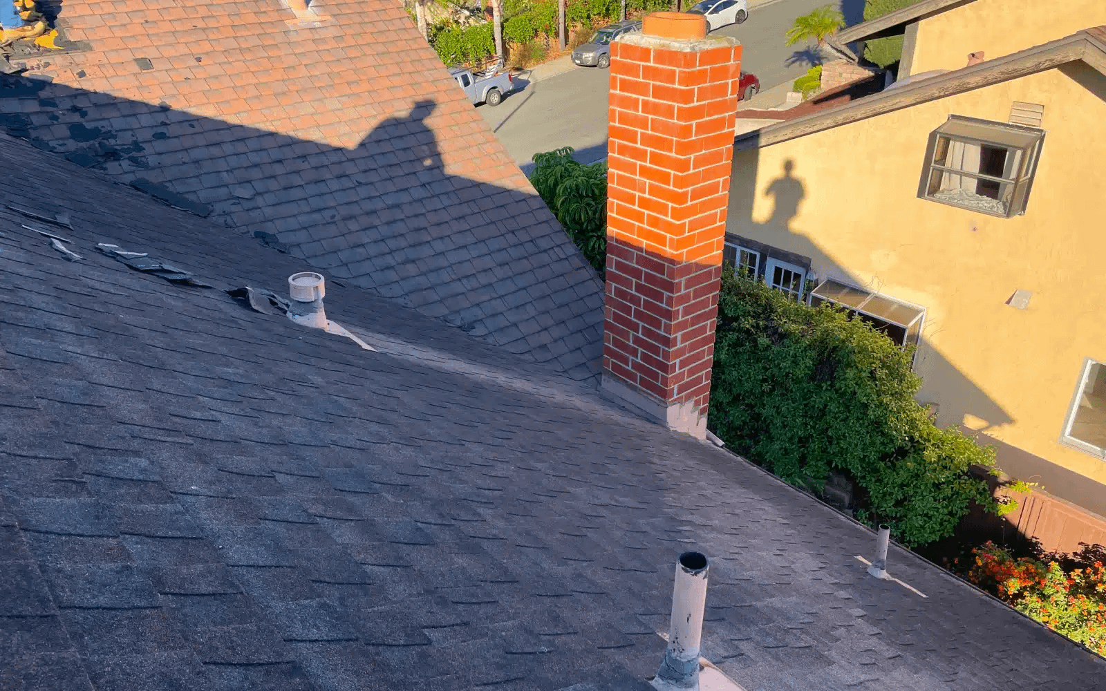 Before roof replacement showing aging asphalt shingle roof and chimney prior to cool roof installation in Rancho Peñasquitos, CA.