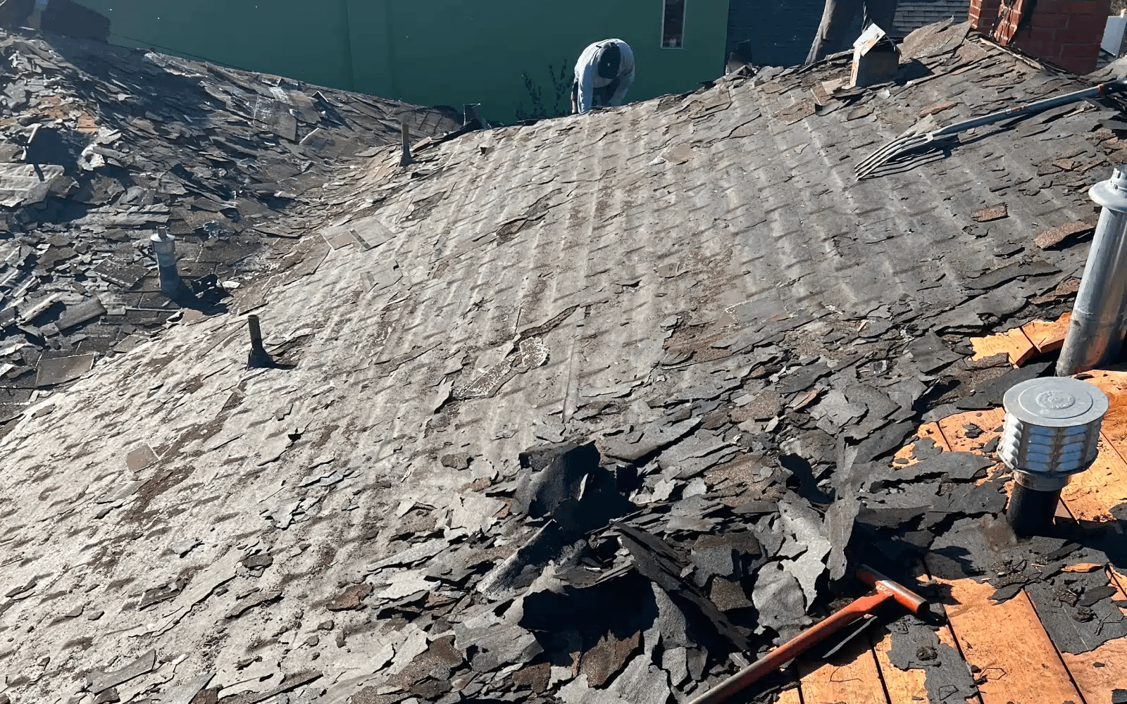 Cool roof replacement in San Carlos, San Diego, CA showing removal of failing asphalt shingle layers during roof tear-off.