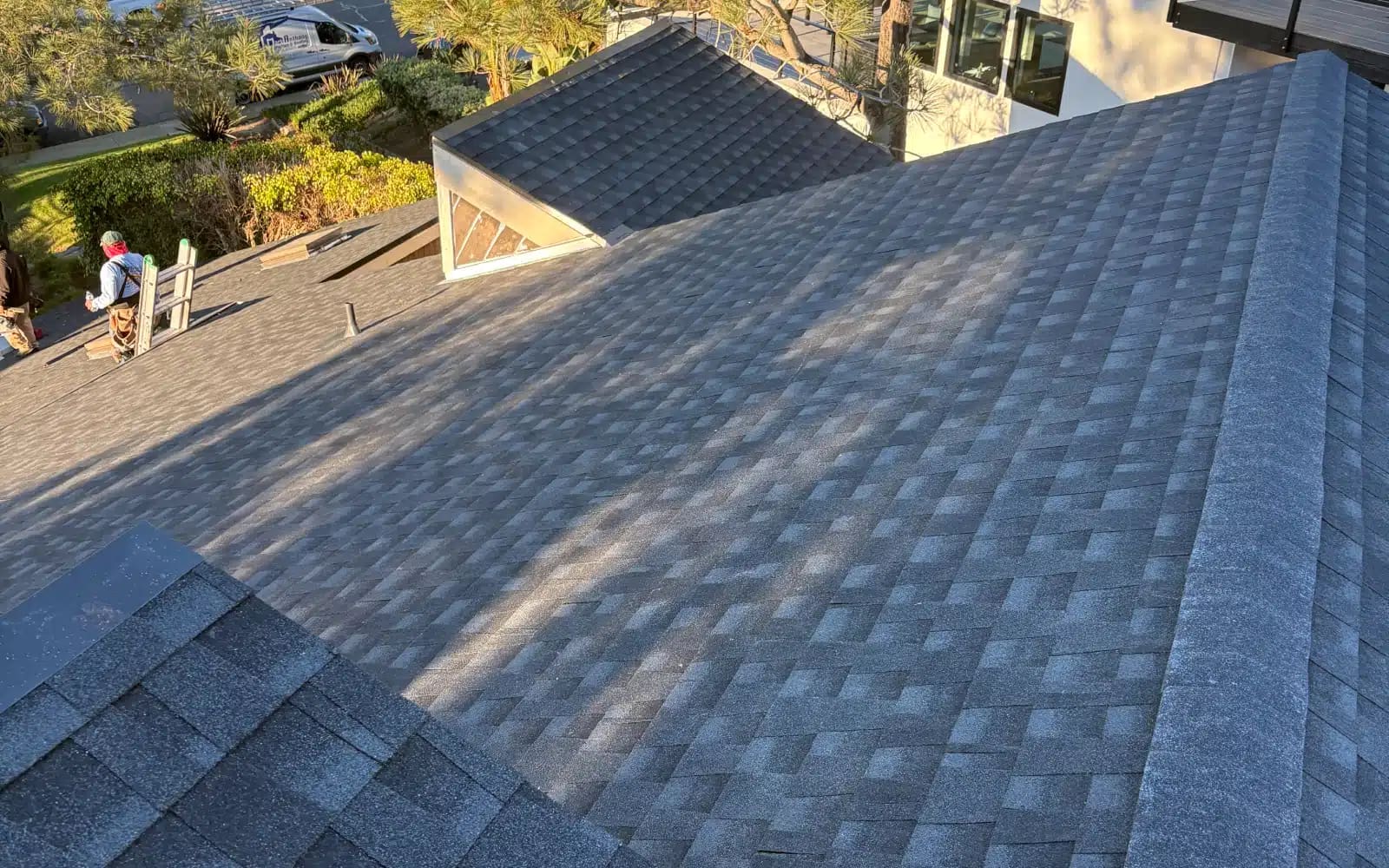 Finished asphalt shingle roof installation showing clean roof plane transitions on a residential home in Del Mar, CA.
