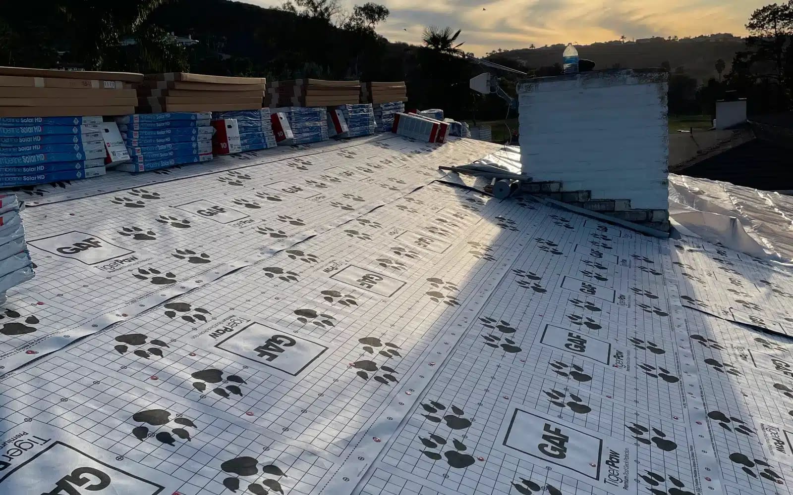 Roof replacement in progress in Lake San Marcos, CA with GAF underlayment installed and materials staged prior to full installation of Timberline Solar™ shingles.