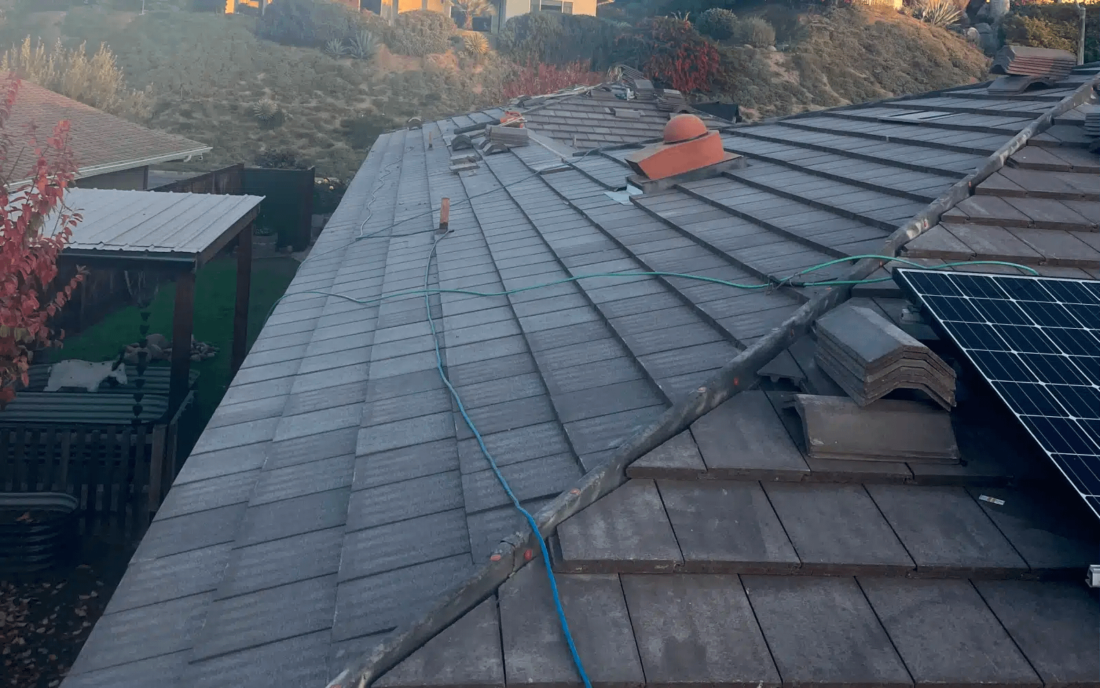 Concrete tile roof replacement in progress in Rancho Bernardo, CA showing underlayment installation and staged roofing materials prior to final tile installation and solar panel reinstallation.
