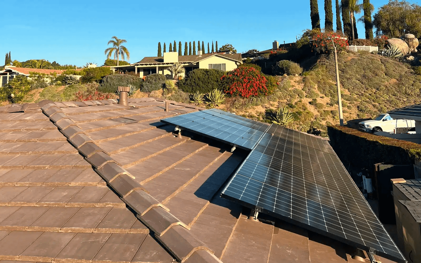 Backyard view of an older concrete tile roofing system in Rancho Bernardo, CA displaying worn tiles and uneven surfaces before coordinated roof replacement.