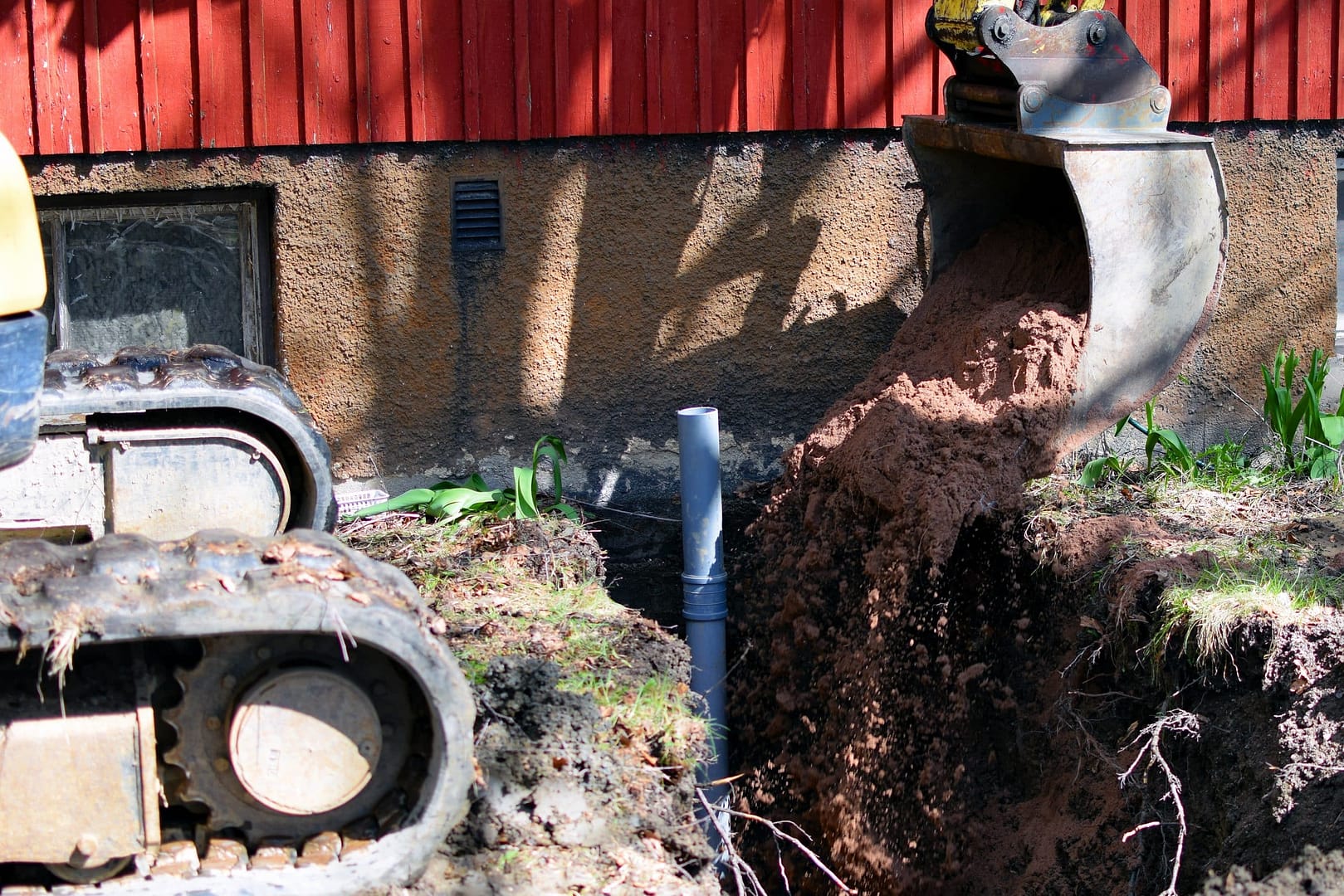 Excavator digging near building foundation. Excavator digging near building foundation.