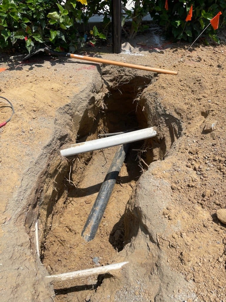 Excavated trench with exposed pipes. Excavated trench with exposed pipes.